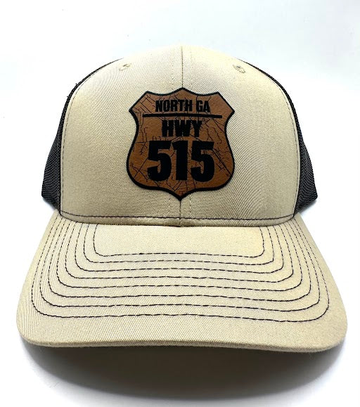 A beige trucker hat with 'NORTH GA HWY 515' embroidered on the front.