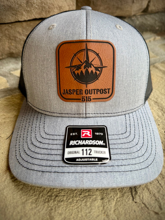 Gray cap with leather patch and Richardson logo on a beige surface